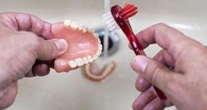 person cleaning their dentures