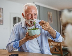 Man smiling while eating lunch at home