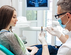 implant dentist in Framingham showing a dental implant to a patient 