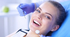A young female smiling as the dentist prepares to perform a regular dental exam during her appointment
