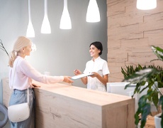 Woman paying for treatment at dental office front desk
