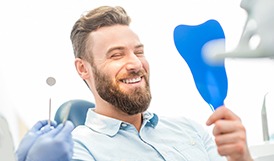 young man admiring his new dental implants in Framingham