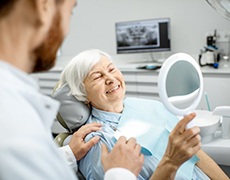 Woman admiring her new dentures in Framingham 