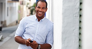 person leaning against a wall and smiling