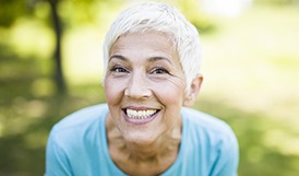 woman with dental implants in Framingham grinning from ear to ear 