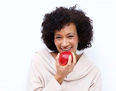 woman biting into a red apple 