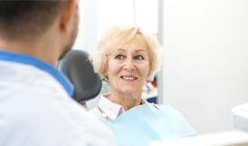 Woman with dental implants in Framingham smiling at her dentist