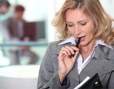 Woman chewing on a pen and reading