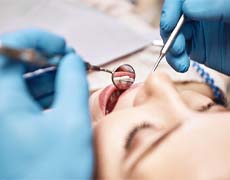 Woman completing dental checkup with an implant dentist in Framingham