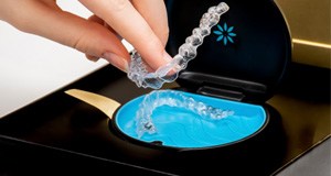 a hand picking up Invisalign aligners 