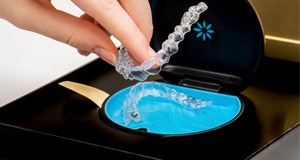 a hand picking up Invisalign aligners