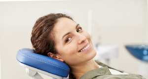 a smiling person sitting in a dental chair