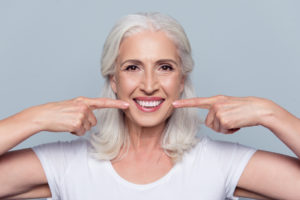 Senior woman pointing to healthy smile