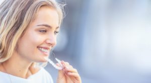 attractive young woman inserting invisalign