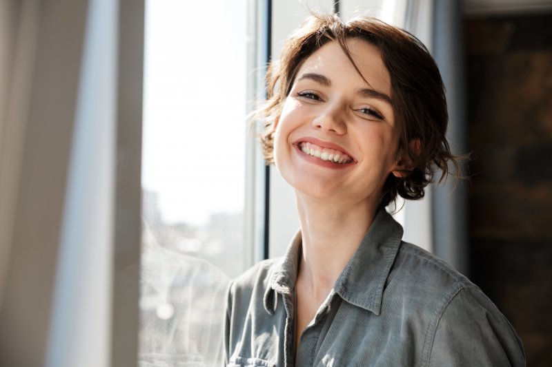 A woman smiling with her newly replaced dental crowns