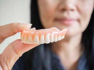 Dentist holding denture. 