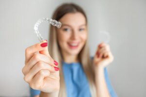 Woman holding Invisalign aligner.