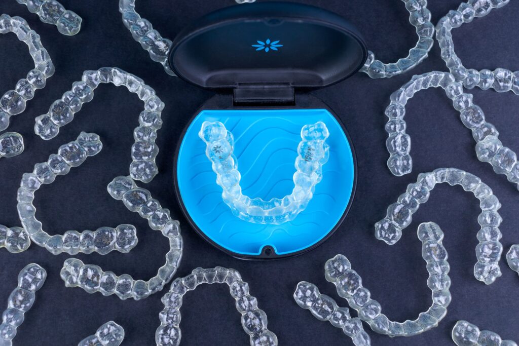 Bird's eye view of many Invisalign trays surrounding its case
